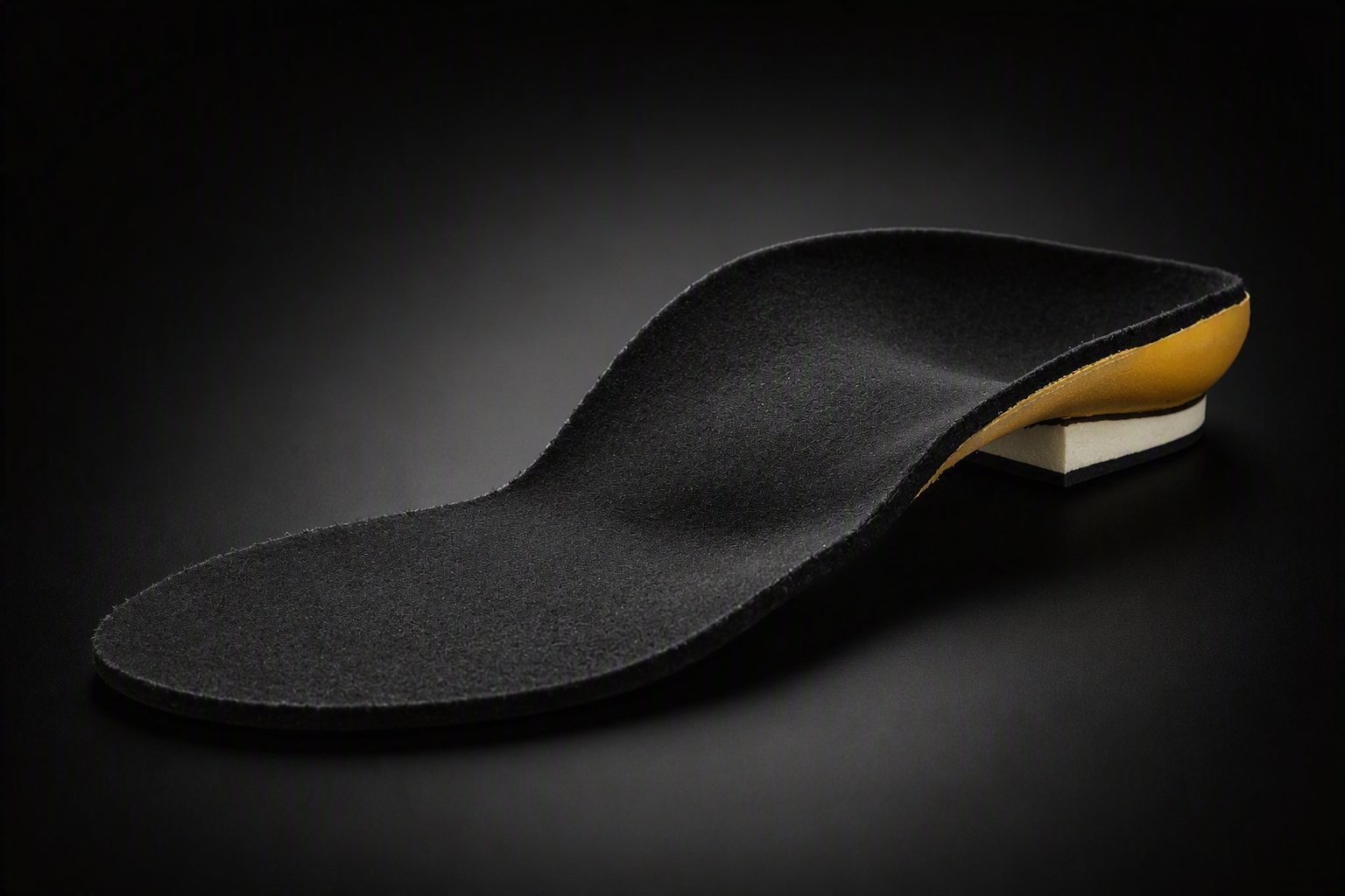 A rigid custom orthotic with a black top cover